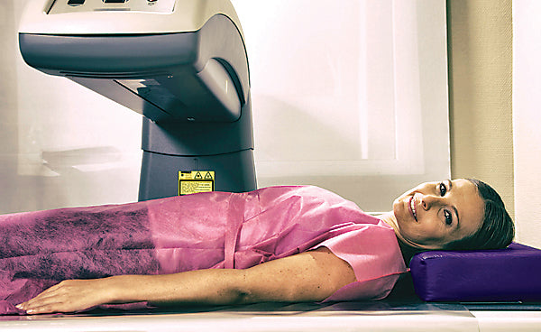 Woman in her 40s undergoing scan at bone densitometer machine